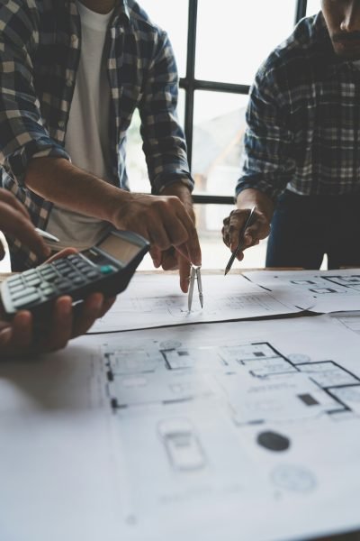 Meeting of plans and calculations on house plan drawings of engineers, architects on blue print with