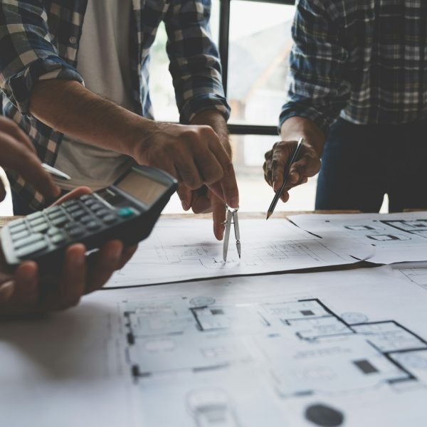 Meeting of plans and calculations on house plan drawings of engineers, architects on blue print with